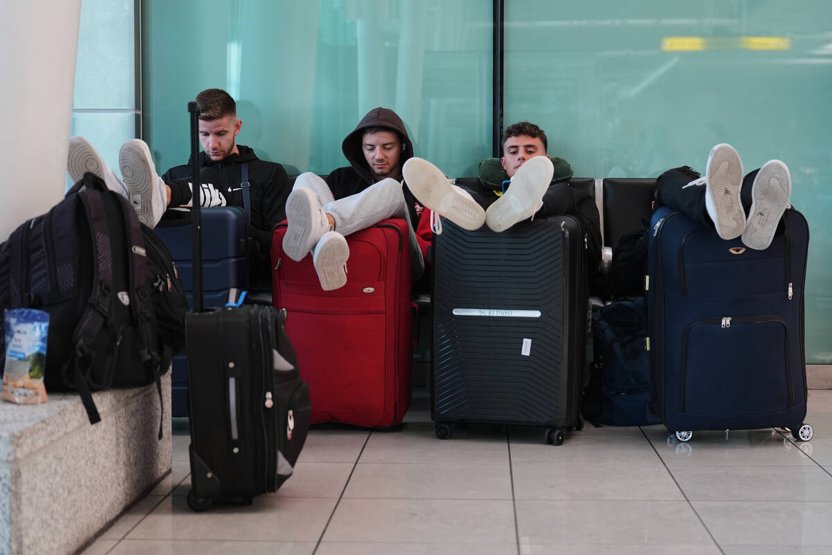 Travelers sit together and wait at the Baltimore/Washington International Thurgood Marshall Air ...