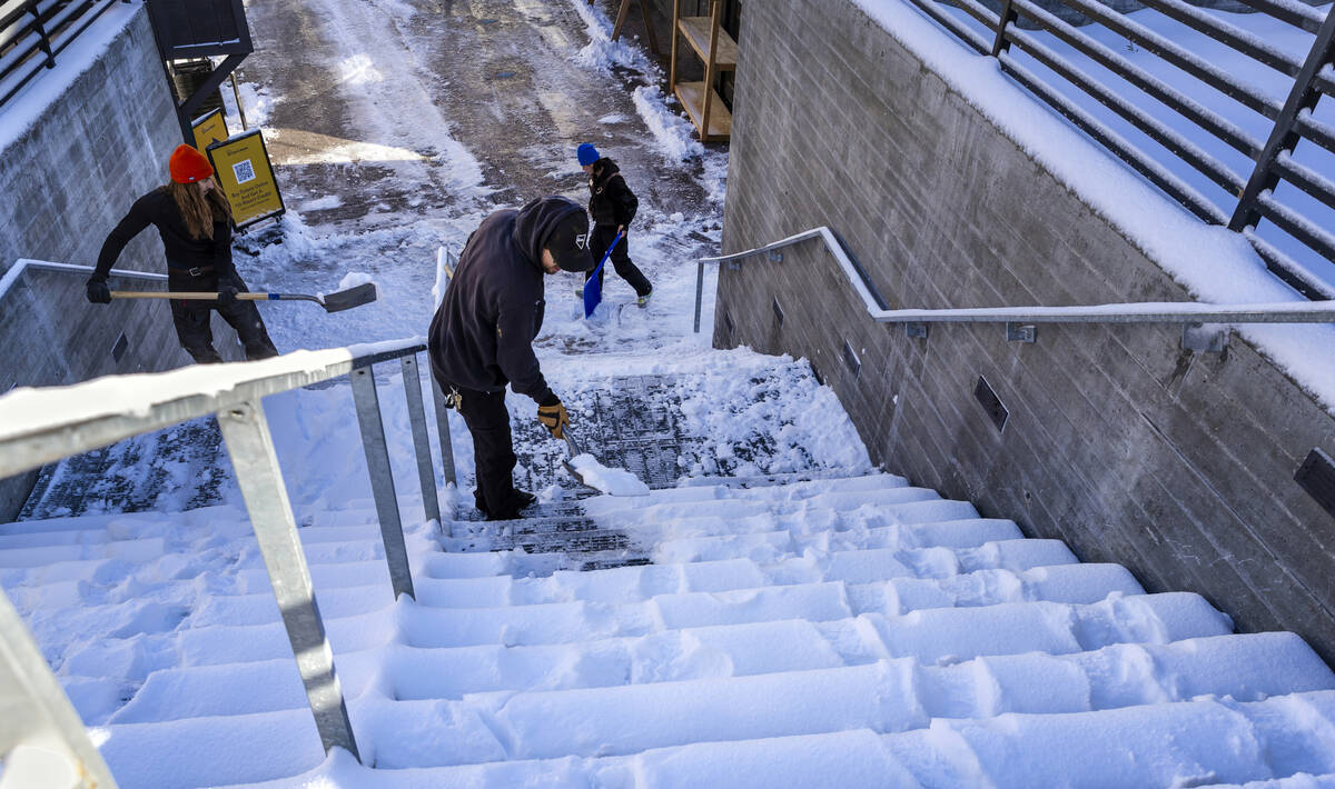A crew shovels the staircase leading to the lodge and lifts at Lee Canyon as the first signifi ...
