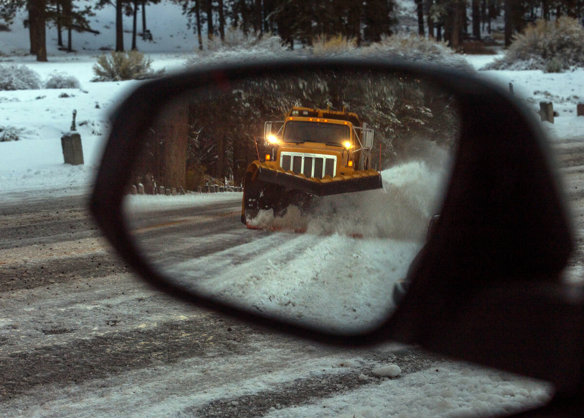 A snow plow works the road to Lee Canyon during the first significant snowfall of the season on ...