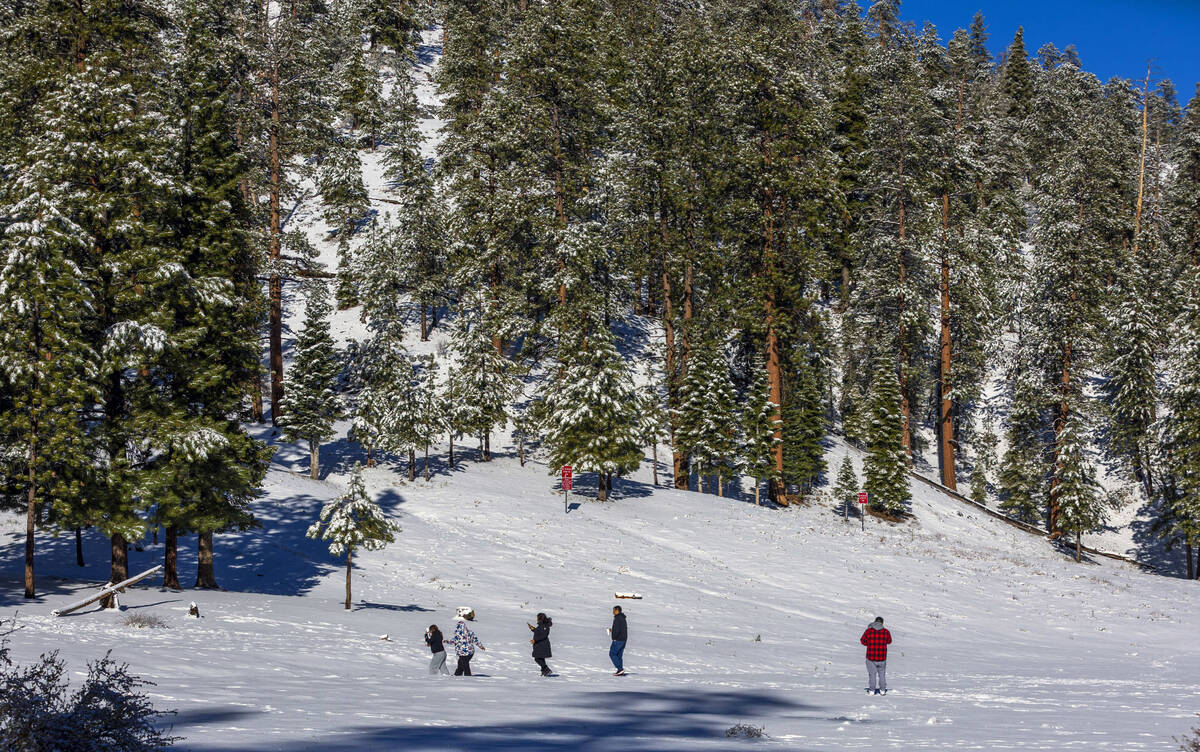 People take a walk in the meadow below the lodge at Lee Canyon during the first significant sno ...