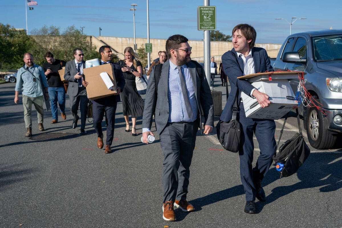 Members of the Pentagon press corp carry their belongings out of the Pentagon after turning in ...