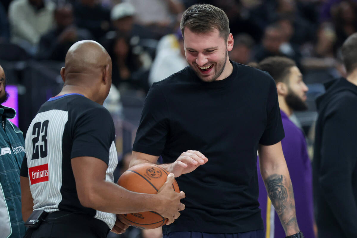 Los Angeles Lakers' Luka Doncic, right, talks to referee Tre Maddox (23) during the first ...