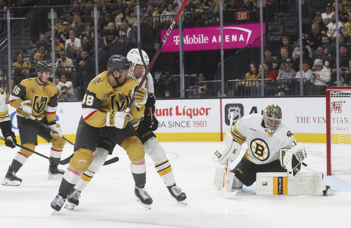 Boston Bruins goaltender Jeremy Swayman (1) stops a shot in front of Golden Knights center Toma ...