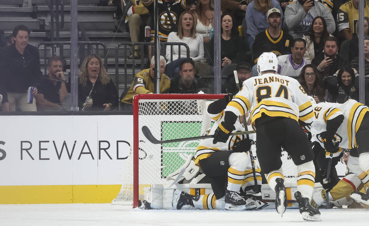The puck, in the lower left of the net, slips past the Boston Bruins goaltender Jeremy Swayman ...