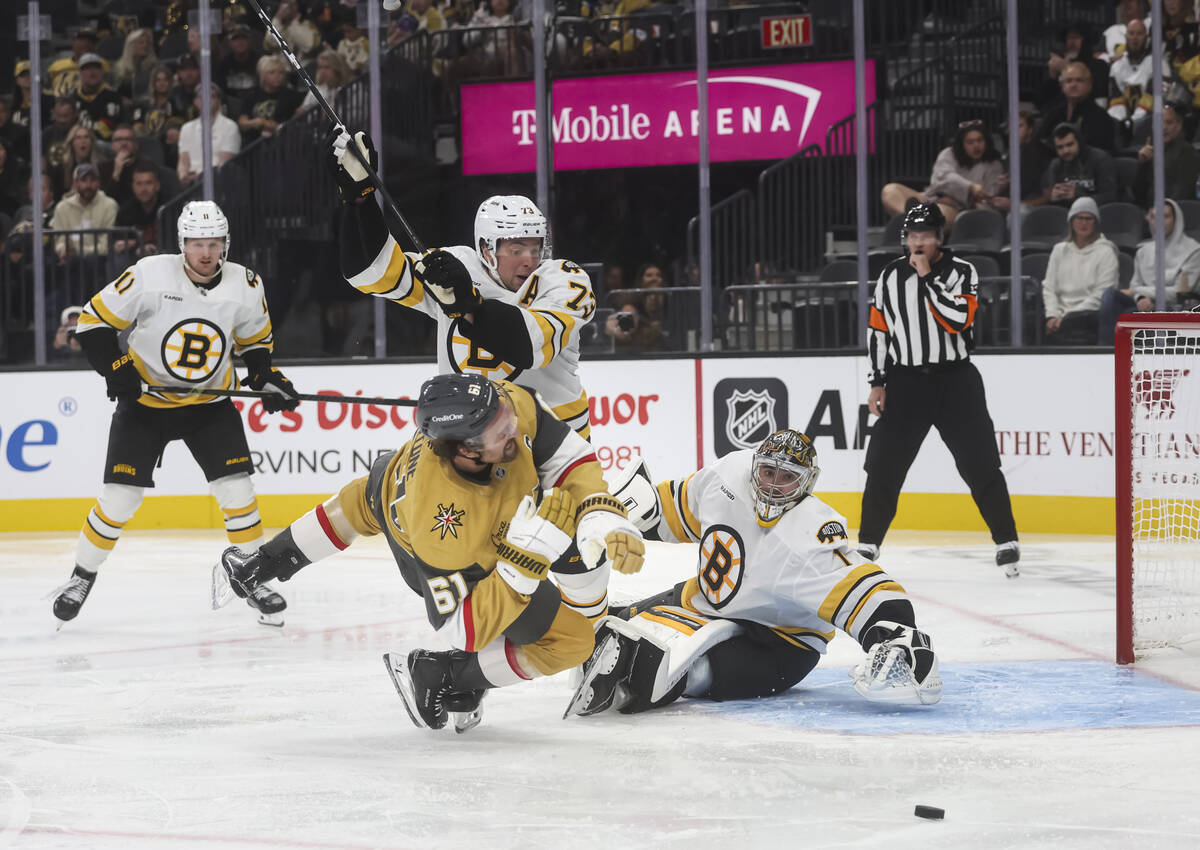 Golden Knights right wing Mark Stone (61) gets high-sticked by Boston Bruins defenseman Charlie ...