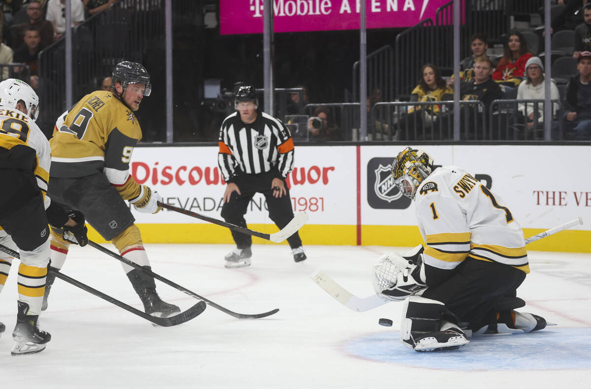 Boston Bruins goaltender Jeremy Swayman (1) blocks a shot from Golden Knights center Jack Eiche ...
