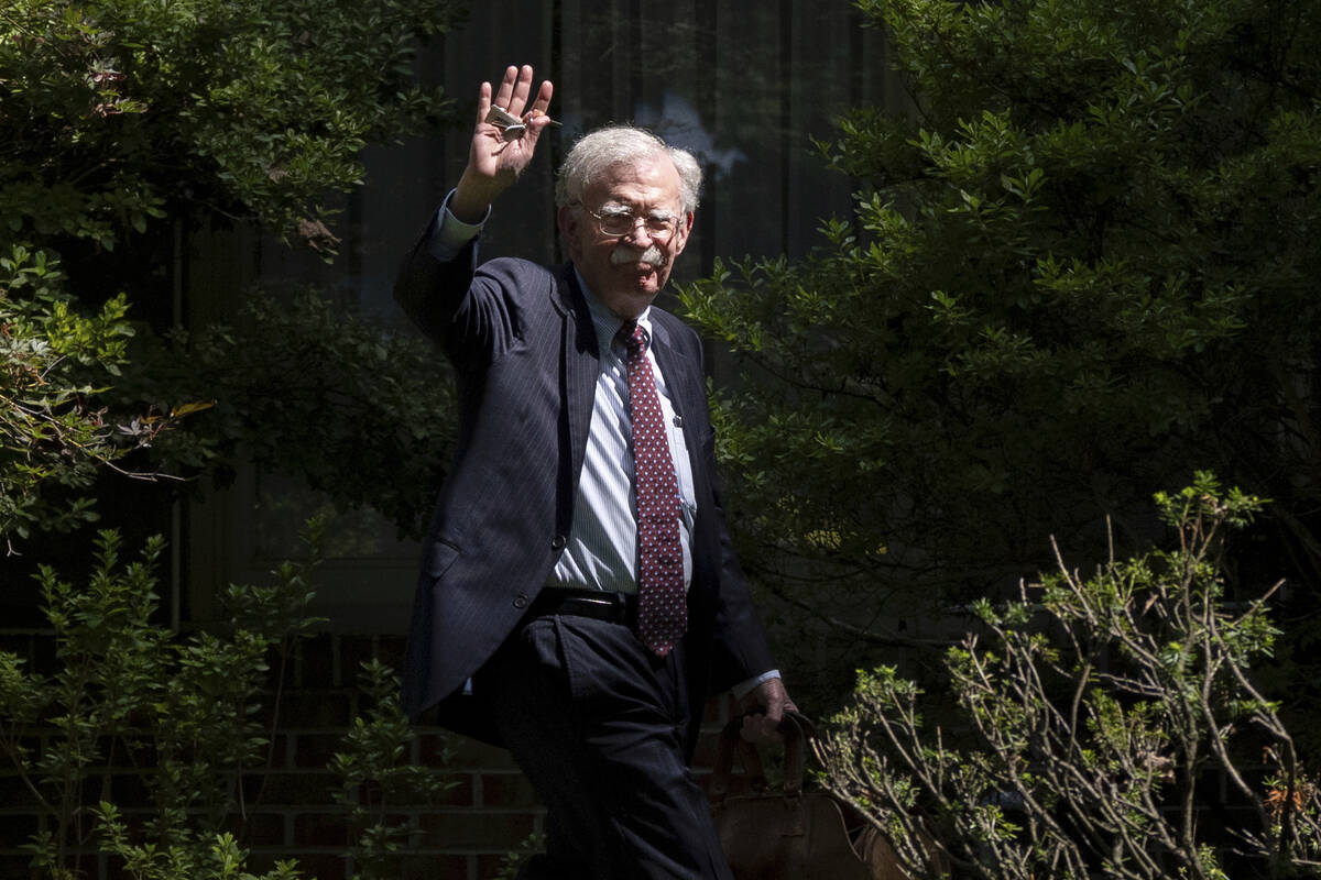 FILE - Former national security adviser John Bolton waves as he arrives at his house Aug. 22, 2 ...