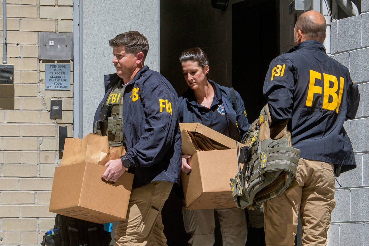 FILE - FBI agents carry boxes from former National Security Advisor John Bolton's office i ...