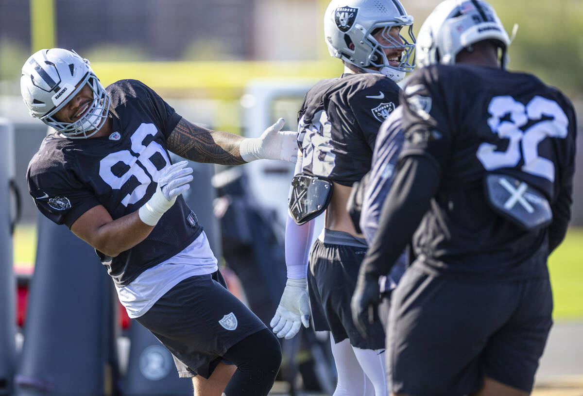 Raiders defensive tackle Jonah Laulu (96) jokes around with Raiders defensive end Maxx Crosby ( ...
