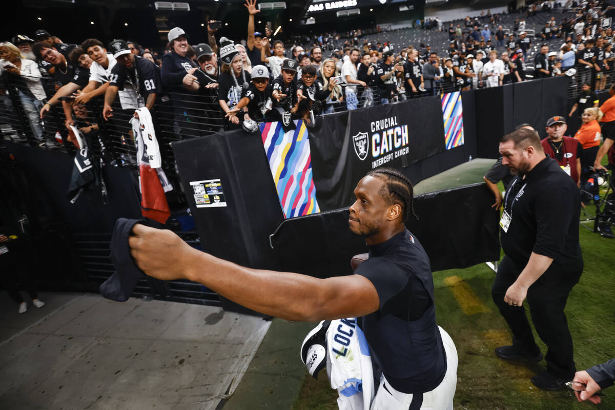 Raiders quarterback Geno Smith hands his sleeve to a fan after defeating the Tennessee Titans i ...