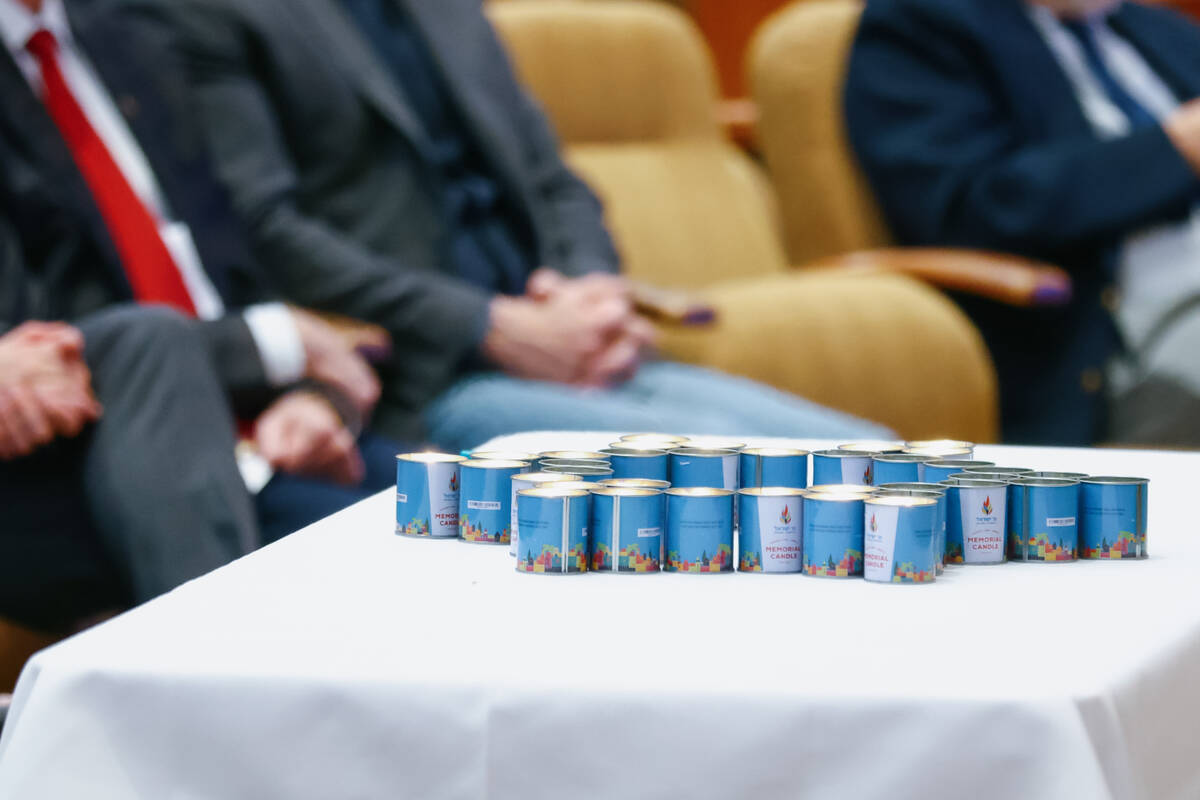 Lit candles, arranged in the shape of the Star of David, sit on a table during an October 7 att ...