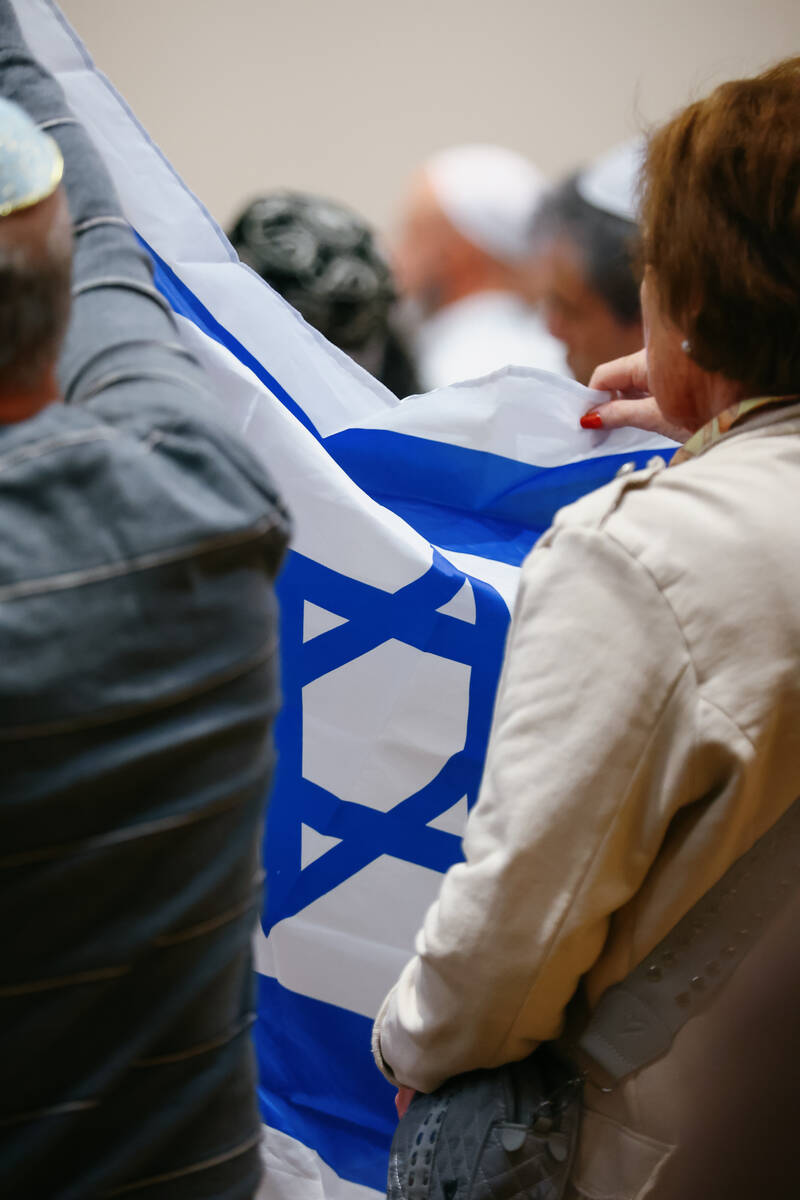 Attendees hold up the Israeli flag while music is played during an October 7 attacks remembranc ...