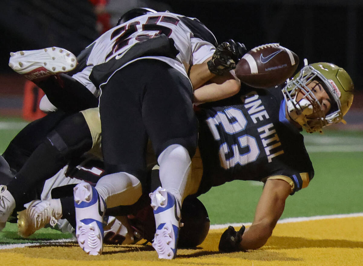 Foothill running back Anthony Taylor (23) loses control of the ball as he crosses the goal line ...