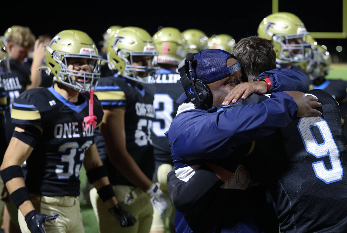 Foothill head coach Vernon Brown hugs Foothill safety Brody Dobbs (9) after making the game cli ...