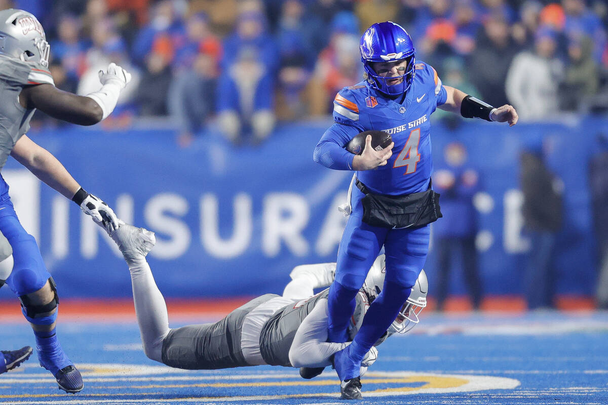 Boise State quarterback Maddux Madsen (4) is tripped by a UNLV defender on a scramble in the fi ...