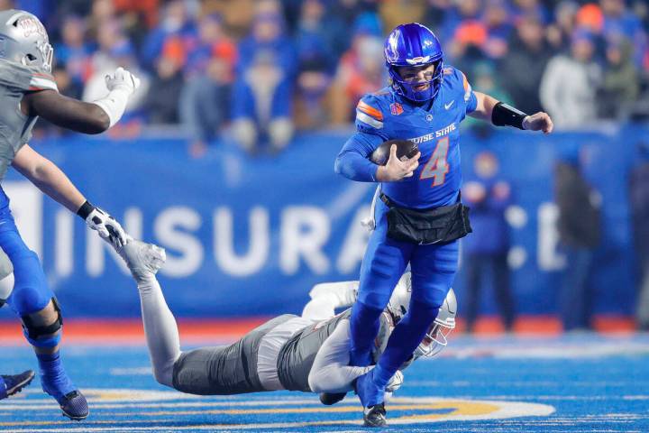 Boise State quarterback Maddux Madsen (4) is tripped by a UNLV defender on a scramble in the fi ...