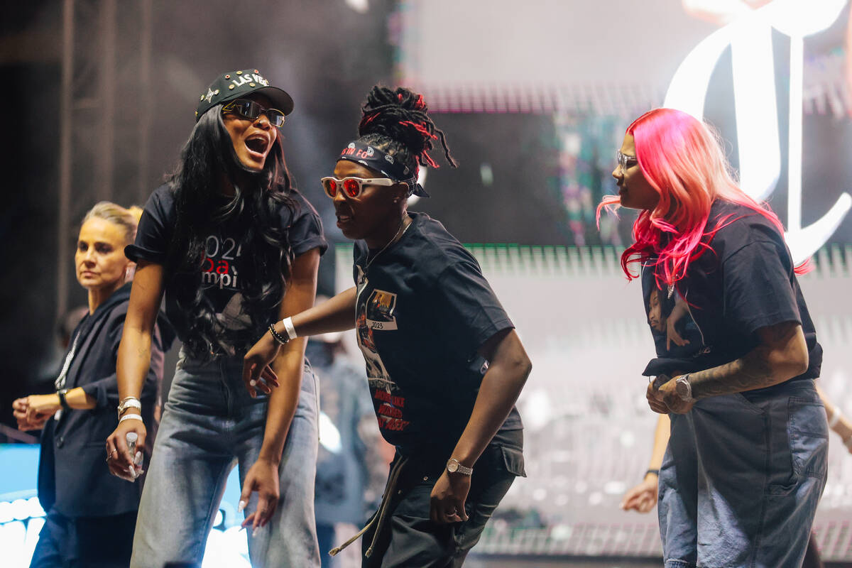 Aces center A'ja Wilson celebrates on stage with guard Chelsea Gray, middle, and forward K ...
