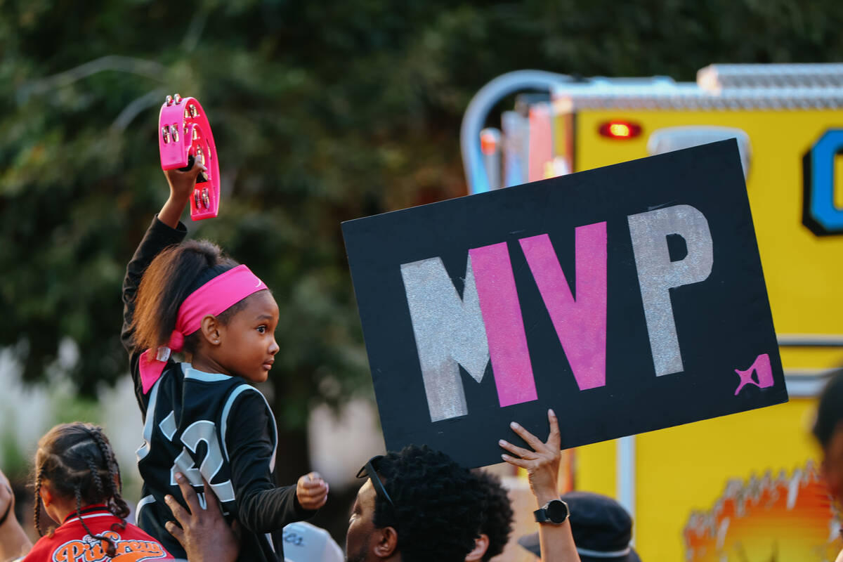 A young fan holds up a tambourine as she watches the Aces’ championship parade on Friday ...