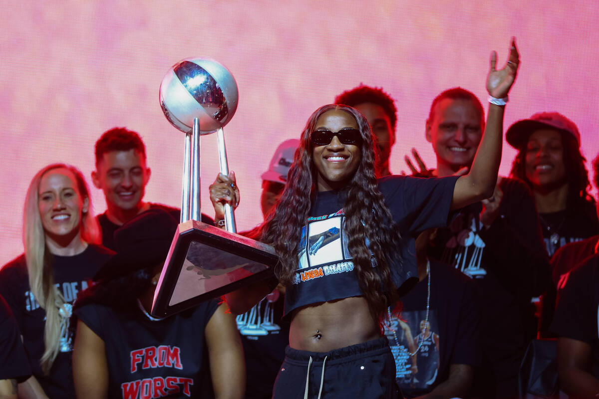 Aces guard Jackie Young walks to the podium with a WNBA Championship Trophy during the Aces&#x2 ...