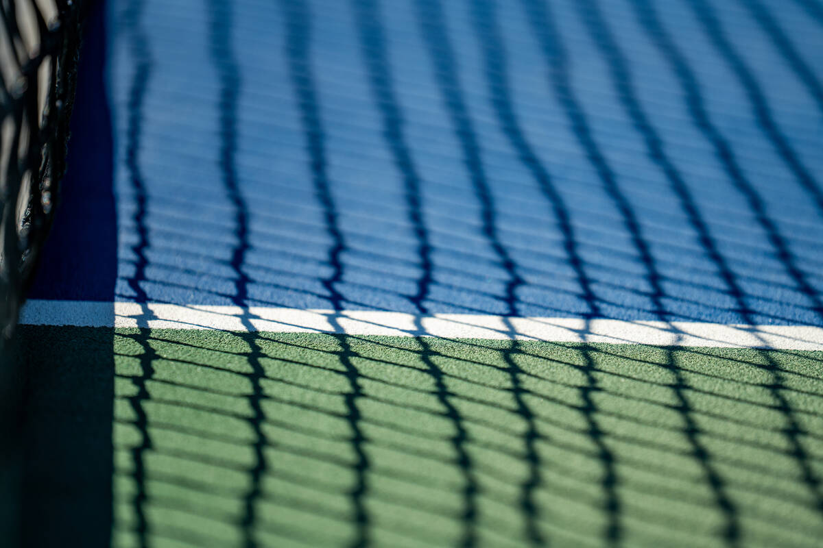 A shadow from the net is cast during the 5A state singles and doubles title matches Friday afte ...