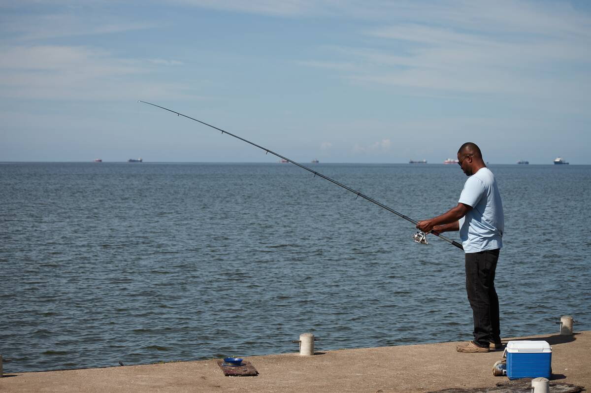 A man fishes in Cocorite, Trinidad and Tobago, Friday, Oct. 3, 2025. (AP Photo/Anselm Gibbs)