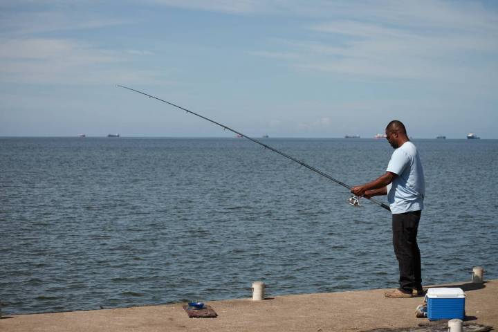 A man fishes in Cocorite, Trinidad and Tobago, Friday, Oct. 3, 2025. (AP Photo/Anselm Gibbs)