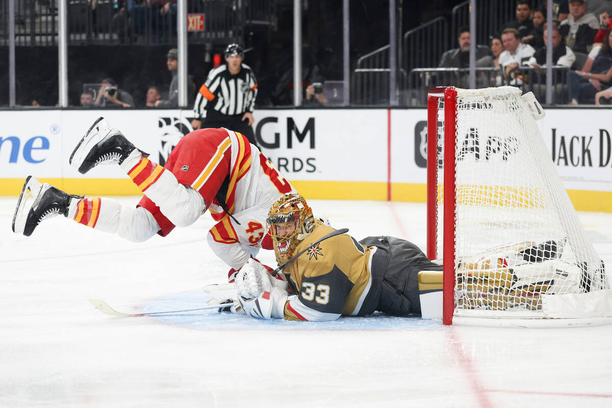 Calgary Flames right wing Adam Klapka (43) collides into Vegas Golden Knights goaltender Adin H ...