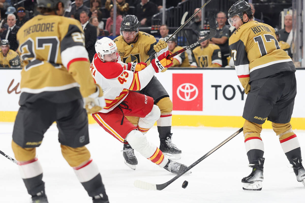 Vegas Golden Knights left wing Ivan Barbashev (49) checks Calgary Flames right wing Adam Klapka ...