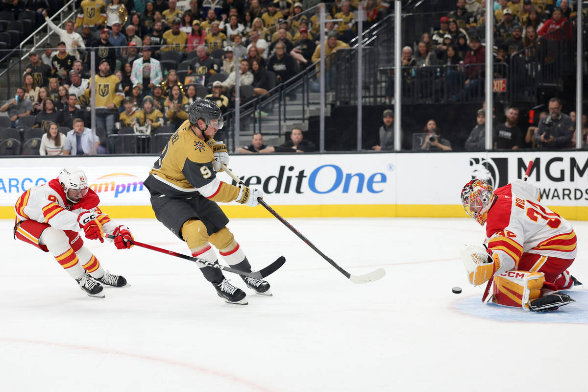 Calgary Flames center Nazem Kadri (91) defends as goaltender Dustin Wolf (32) stops a shot from ...