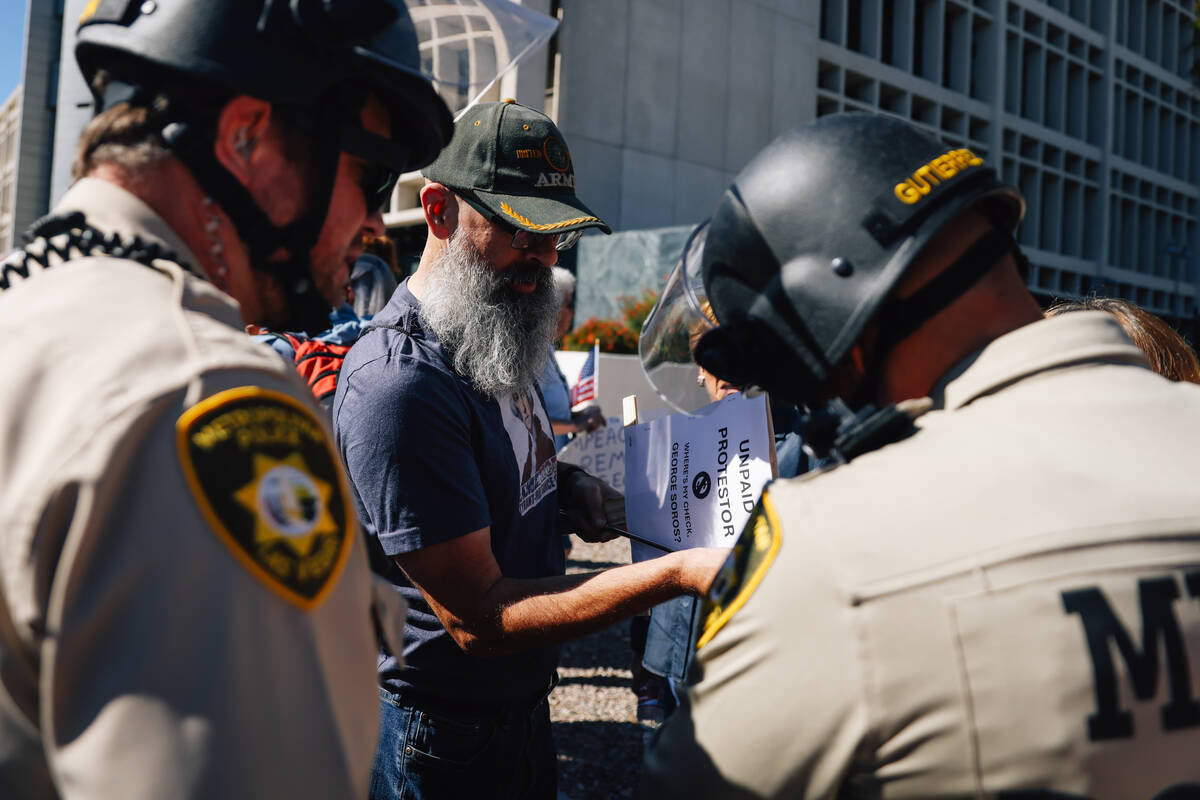 Officers with the Metropolitan Police Department police confront a protestor over a stick on hi ...