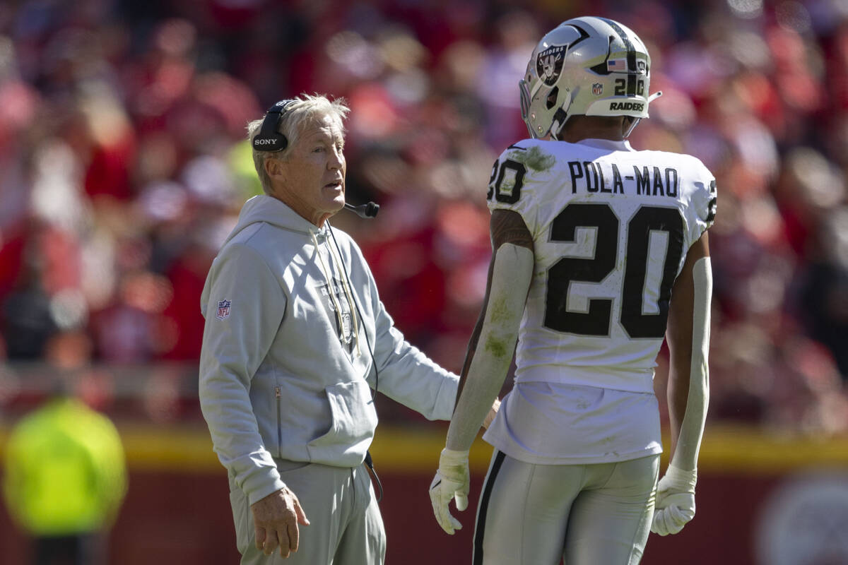 Raiders head coach Pete Carroll speaks to safety Isaiah Pola-Mao (20) during the first half of ...