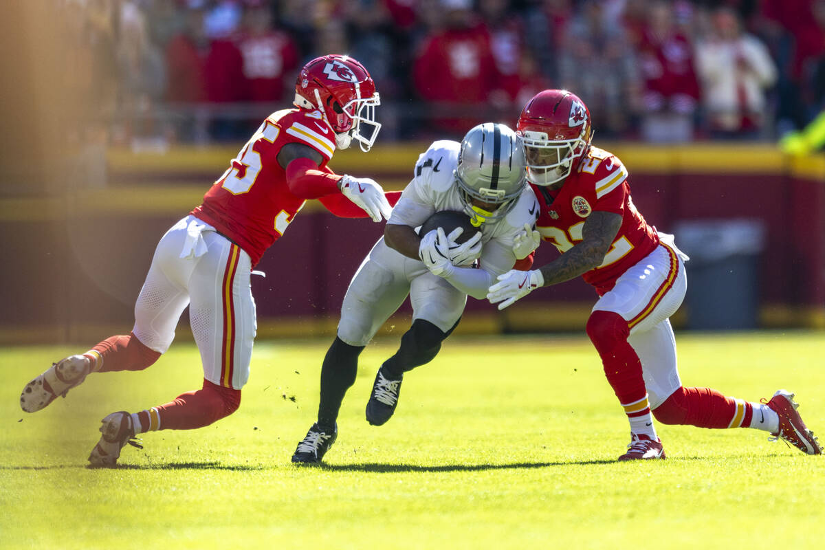 Raiders wide receiver Tre Tucker (1) is tackled by Kansas City Chiefs cornerback Jaylen Watson ...