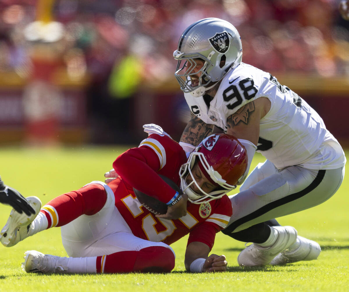 Kansas City Chiefs quarterback Patrick Mahomes (15) slides as he is pressured by Raiders defens ...