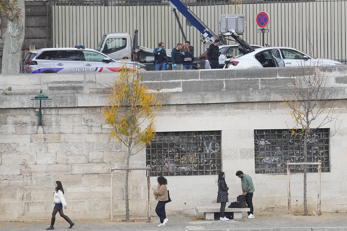 Police officers work by a basket lift used by thieves at the Louvre museum after a robbery Sund ...