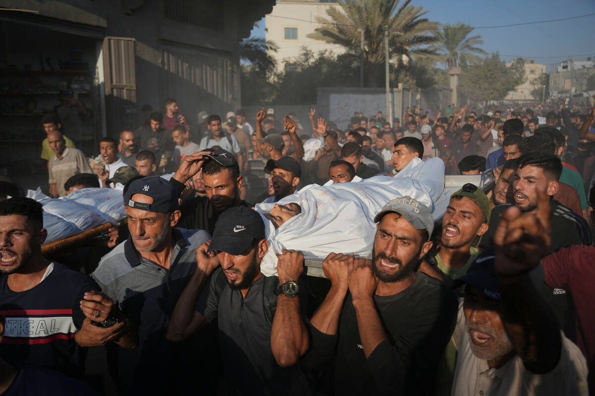 Mourners carry bodies of Palestinians killed by Israeli fire, during their funeral in Deir al-B ...