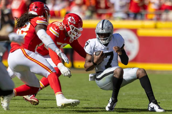 Raiders quarterback Geno Smith (7) is pursued by Kansas City Chiefs linebacker Nick Bolton (32) ...