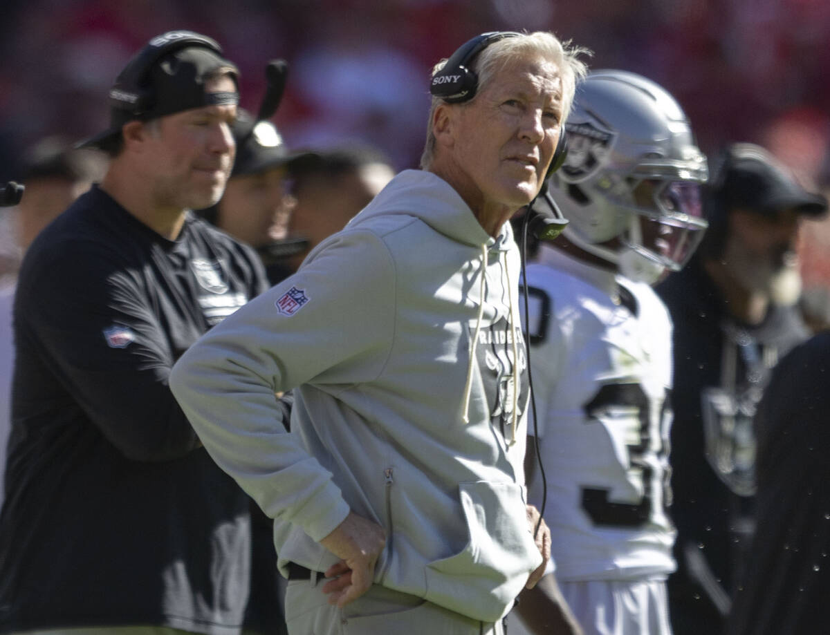 Raiders head coach Pete Carroll looks to a replay screen during the first half of an NFL game a ...