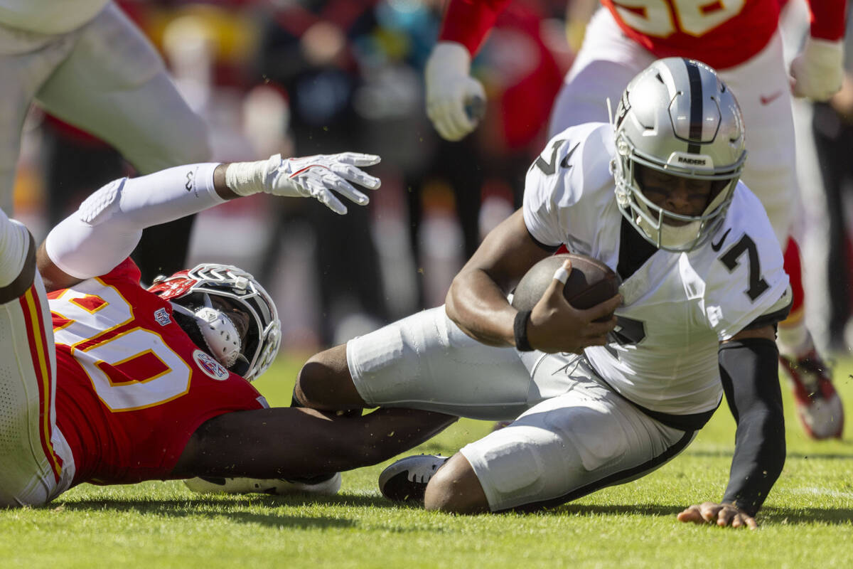 Raiders quarterback Geno Smith (7) is tackled by Kansas City Chiefs defensive end Charles Omeni ...