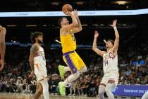 Los Angeles Lakers forward/guard Luka Doncic (77) shoots between Phoenix Suns Isaiah Livers and ...