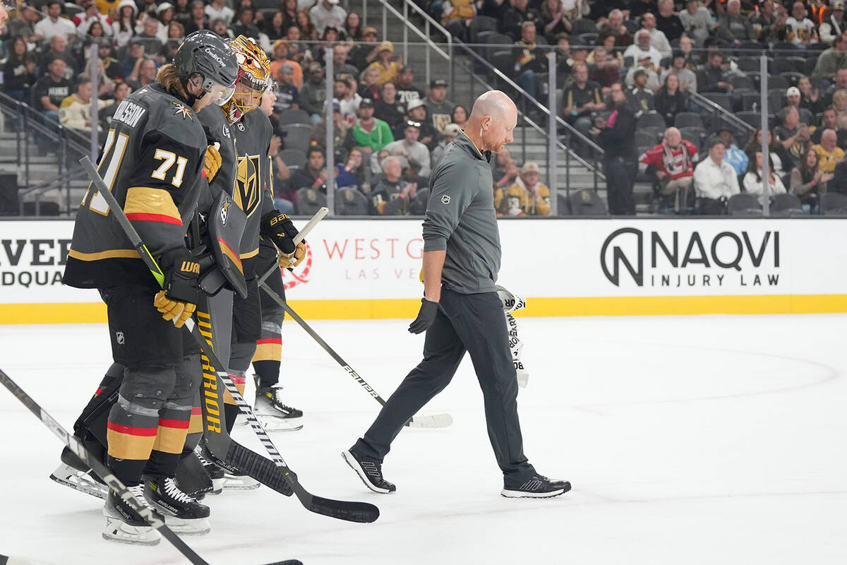 Vegas Golden Knights goaltender Adin Hill, second from left, is helped off the ice during the f ...
