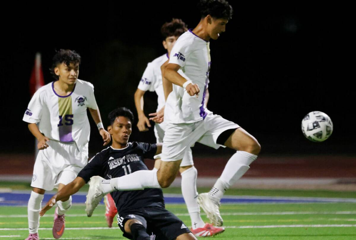 Desert Pines Jesus Nunez (11) slides to defend Sunrise Mountain defensive midfielder Antonio Be ...