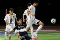 Desert Pines Jesus Nunez (11) slides to defend Sunrise Mountain defensive midfielder Antonio Be ...