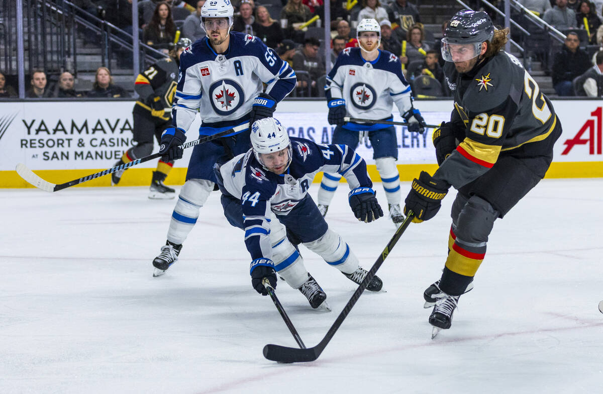 Golden Knights left wing Brandon Saad (20) attempts to shoot as Winnipeg Jets defenseman Josh M ...