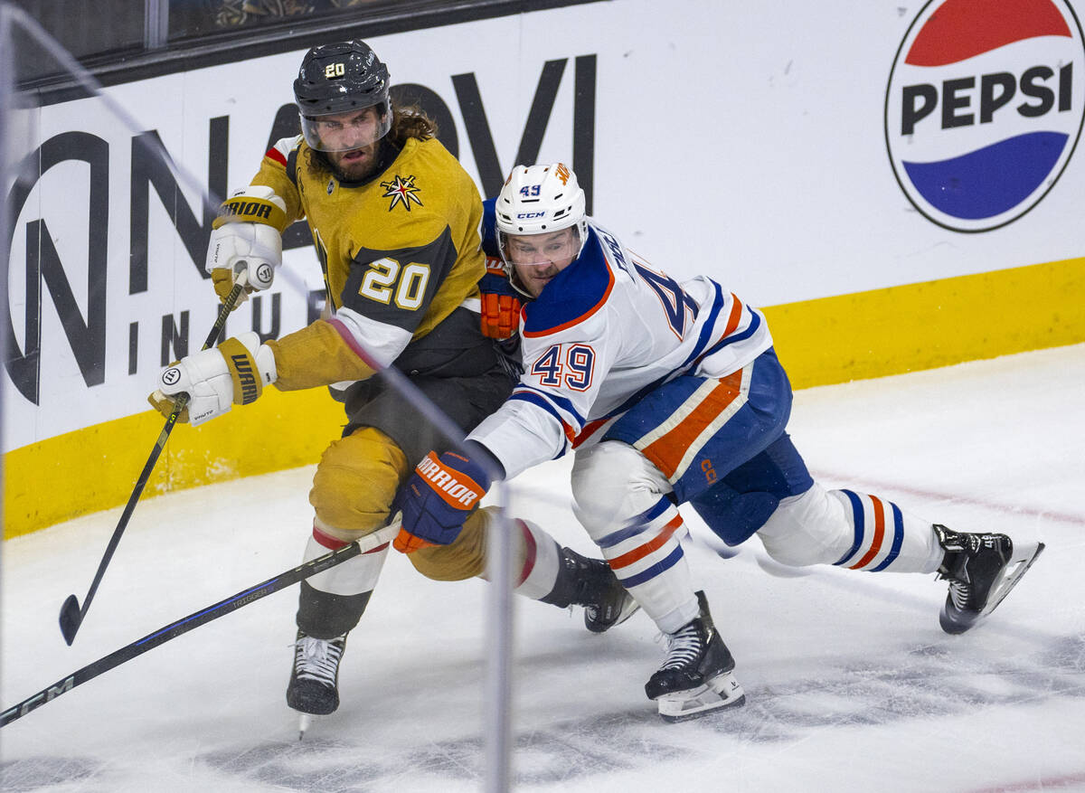 Golden Knights left wing Brandon Saad (20) battles for the puck with Edmonton Oilers defenseman ...