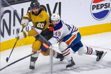 Golden Knights left wing Brandon Saad (20) battles for the puck with Edmonton Oilers defenseman ...