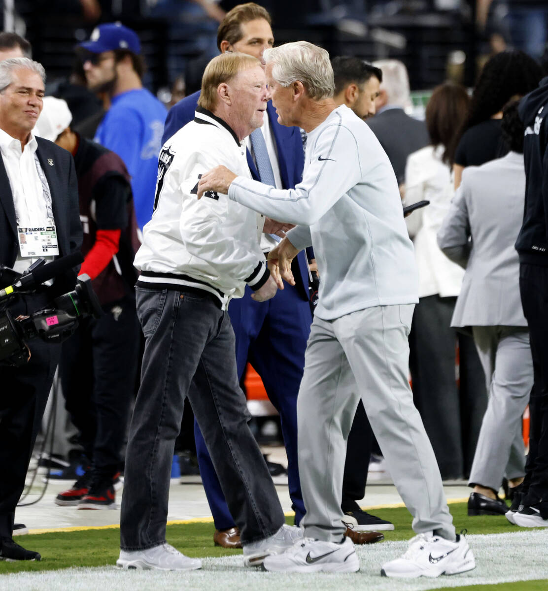Raiders head coach Pete Carroll and owner Mark Davis greet each other prior to an NFL football ...