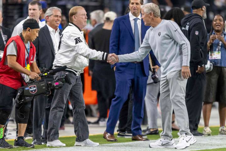 Raiders owner Mark Davis, left, shakes hands with head coach Pete Carroll, right, as ESPN sport ...