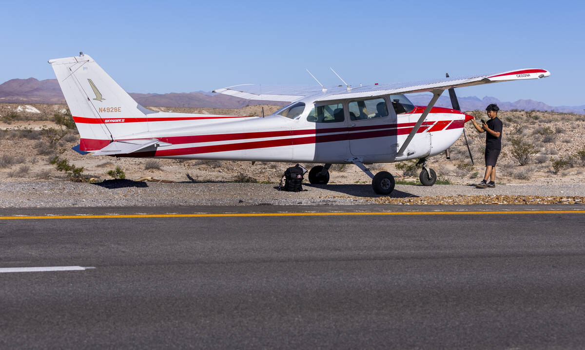 Pilot Tzuriel Urbano makes a call next to the nose of his plane after safely landing it on Inte ...