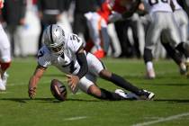 Las Vegas Raiders quarterback Geno Smith (7) recovers his own fumble during the first half of a ...