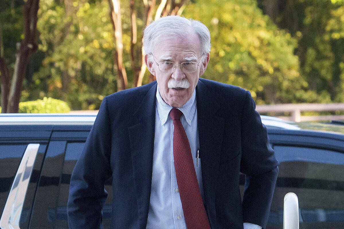 Former Trump administration national security adviser John Bolton, left, arrives for his arraig ...